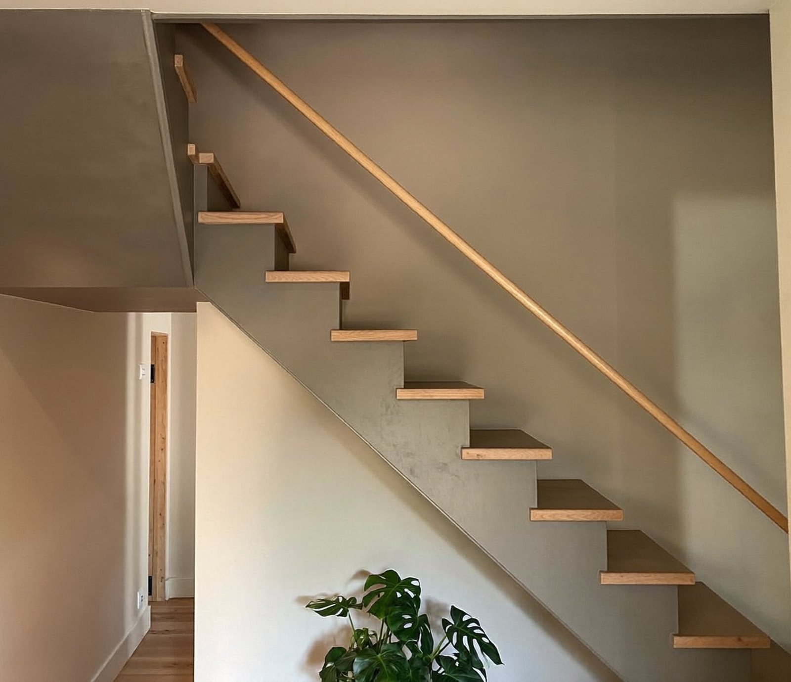 Holztreppe mit Setzstufen und Wange in glattem Graubeige, Handlauf aus Holz, digital erzeugte Darstellung